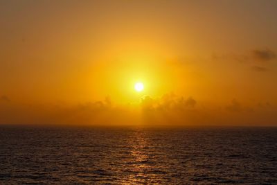 Scenic view of sea against orange sky