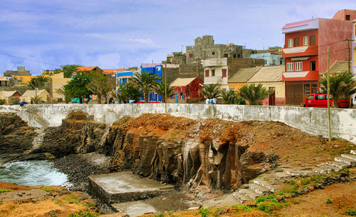 Buildings by rocks in city against sky