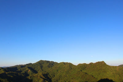 Scenic view of mountains against clear blue sky