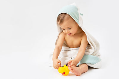 Portrait of young woman holding toy against white background