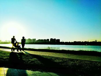 Sun shining over river in city