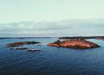 Rock formation in sea against sky