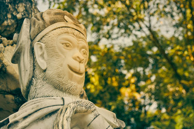 Low angle view of statue against trees in park