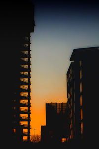 Low angle view of silhouette buildings against sky during sunset