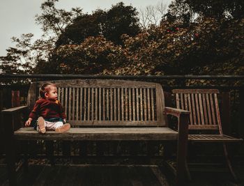 Full length of baby boy sitting on wooden bench