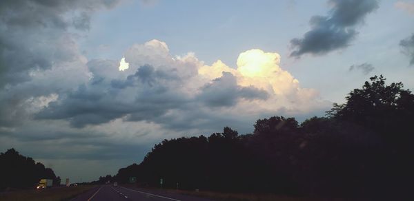 Road amidst trees against sky