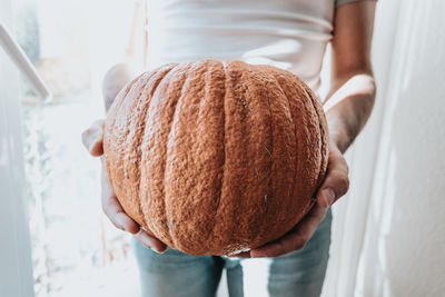 Midsection of woman holding pumpkin