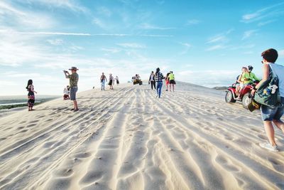 People on beach against sky during winter