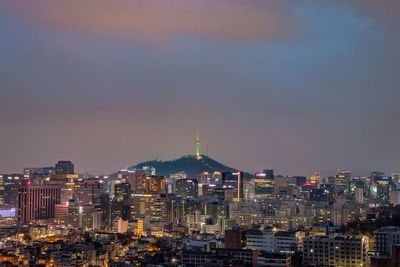 View of city lit up against sky