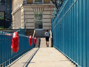 Rear view of man walking on footpath