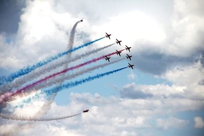 Low angle view of airplane against cloudy sky