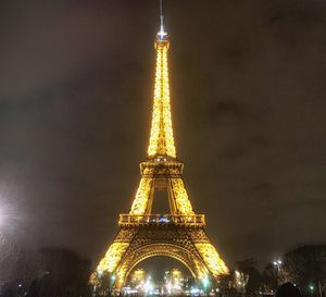 Low angle view of illuminated tower against sky at night