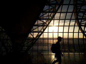 Silhouette man standing on bridge against sky