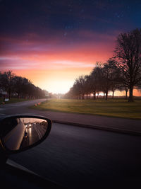 Car on street against sky during sunset