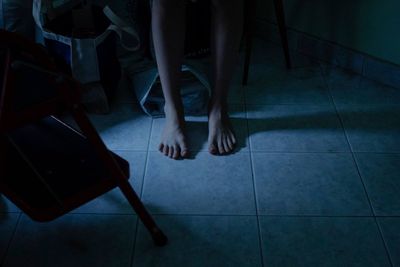 Low section of people standing on tiled floor at home