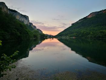 Scenic view of lake by mountains against sky