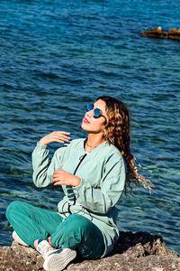 Woman sitting with umbrella in water