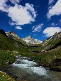 Scenic view of lake by mountains against sky