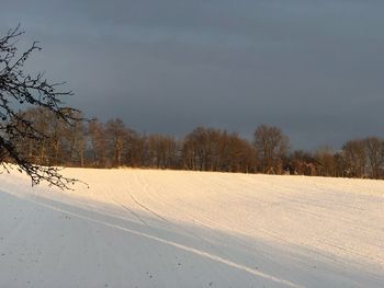 Snow covered field against sky