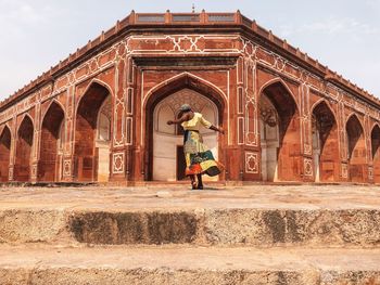 Full length of man standing by historic building against sky