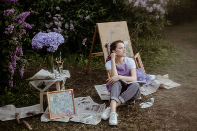 Full length of a girl artist sitting on paper