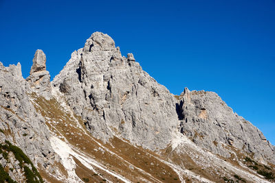 Low angle view of mountain against clear blue sky