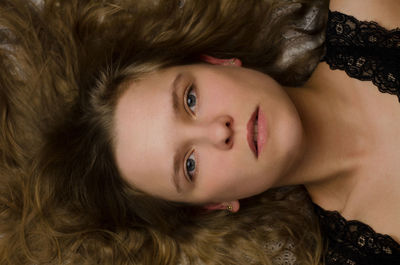 Close-up portrait of young woman lying down