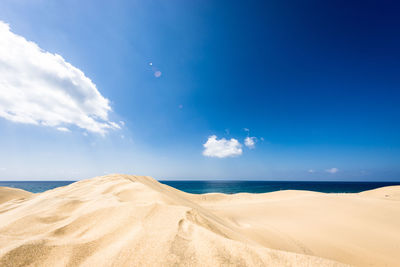 Scenic view of beach against blue sky