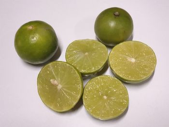 High angle view of green fruits against white background