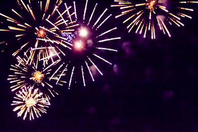 Low angle view of firework display in sky at night