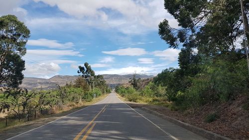 Road amidst trees against sky