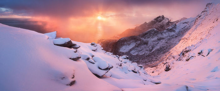Snow covered mountain against sky during sunset