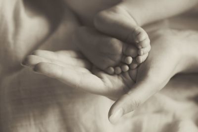 Close-up of hand holding baby feet