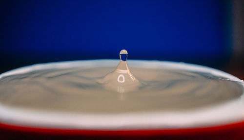 Close-up of drop falling in a cup