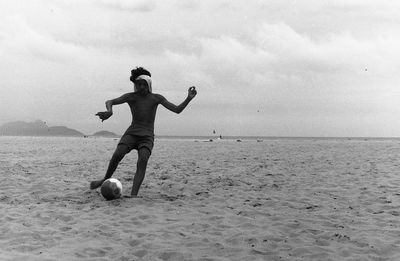 Rear view of woman standing on beach