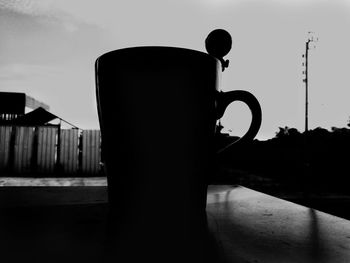 Close-up of silhouette coffee cup against sky