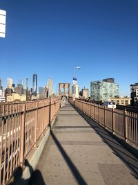 Street amidst buildings against clear blue sky