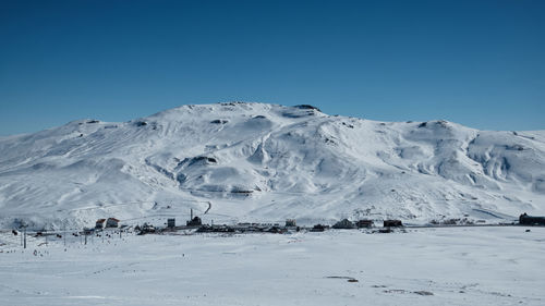 Snow covered mountain slope with clouds and bright blue sky. winter snowy morning mountain landscape