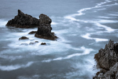 Rock formation on beach against sky