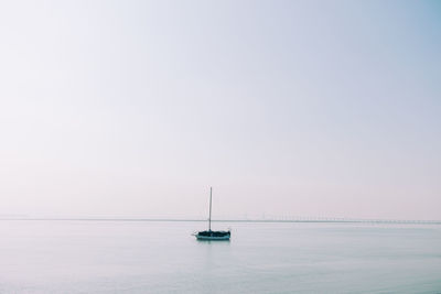 Sailboat on sea against clear sky