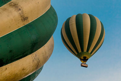 Low angle view of hot air balloons flying against clear sky