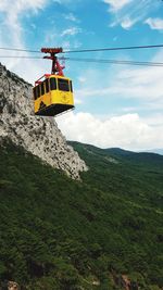 Overhead cable car on road against sky