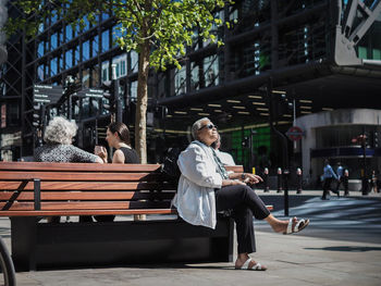 People sitting on bench in city