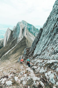 Two young female climber ascending steep mountain face in switzerland