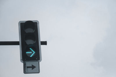 Low angle view of road signal against sky