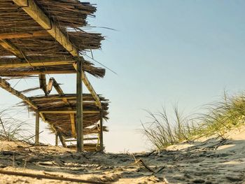 Hut on beach against clear sky