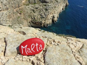 Close-up of text on rock by sea