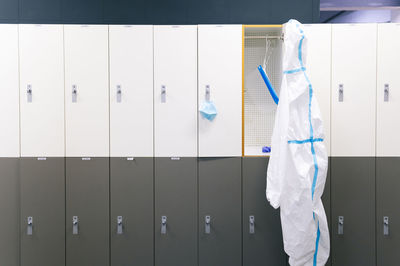 Protective wear and face shield hanging on locker in hospital