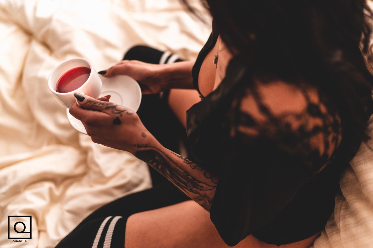 HIGH ANGLE VIEW OF WOMAN HOLDING COFFEE