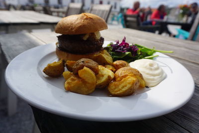 Close-up of hamburger in plate on table at sidewalk cafe